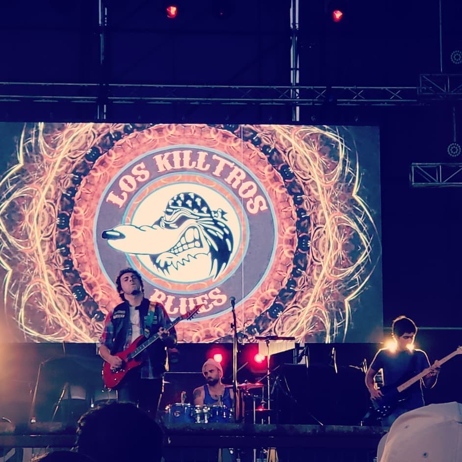 Los Killtros Blues sobre el escenario con el logo iluminado