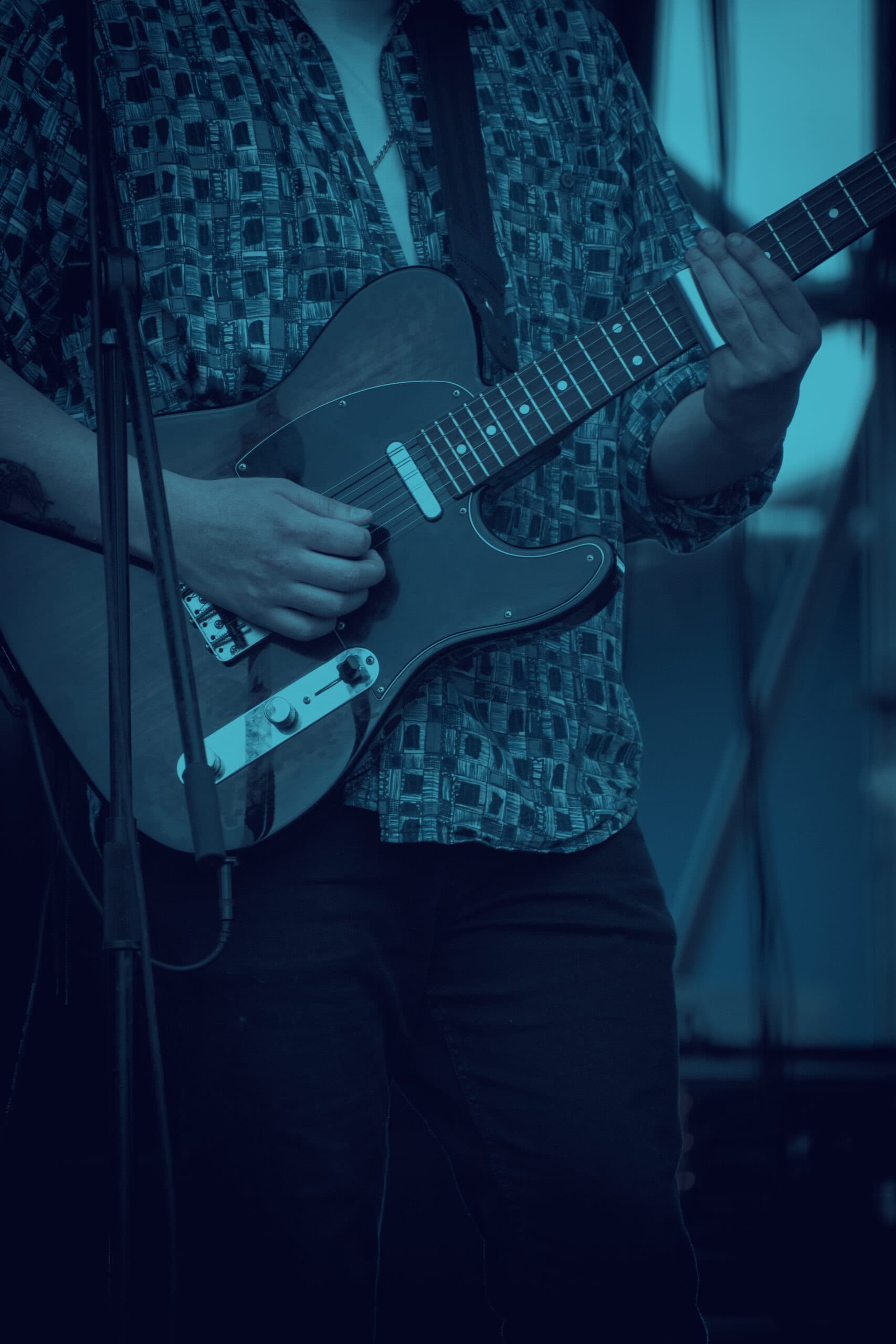 Retrato vertical de un integrante de Los Killtros Blues con guitarra roja